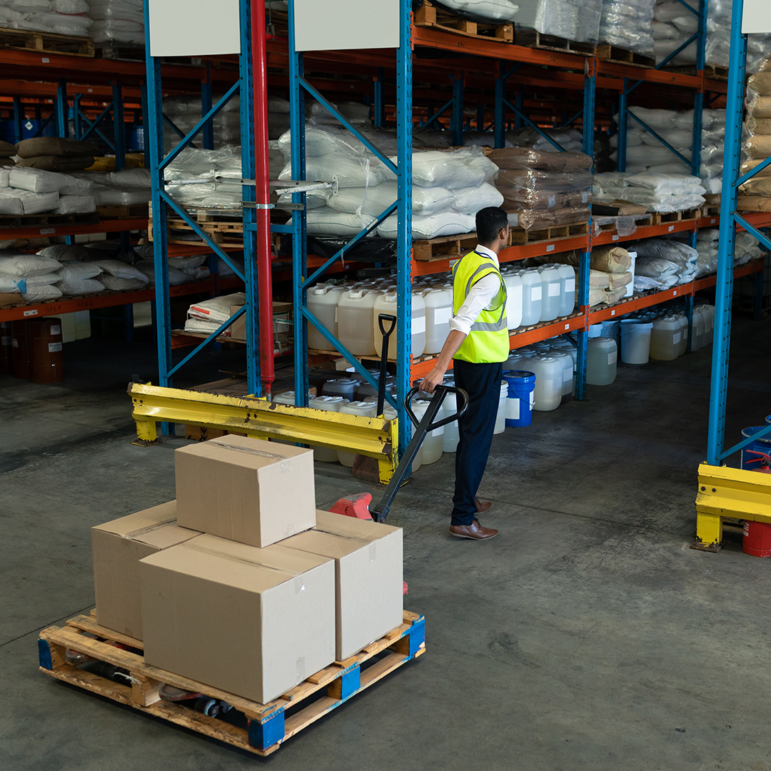 warehouse worker organizing large taped boxes