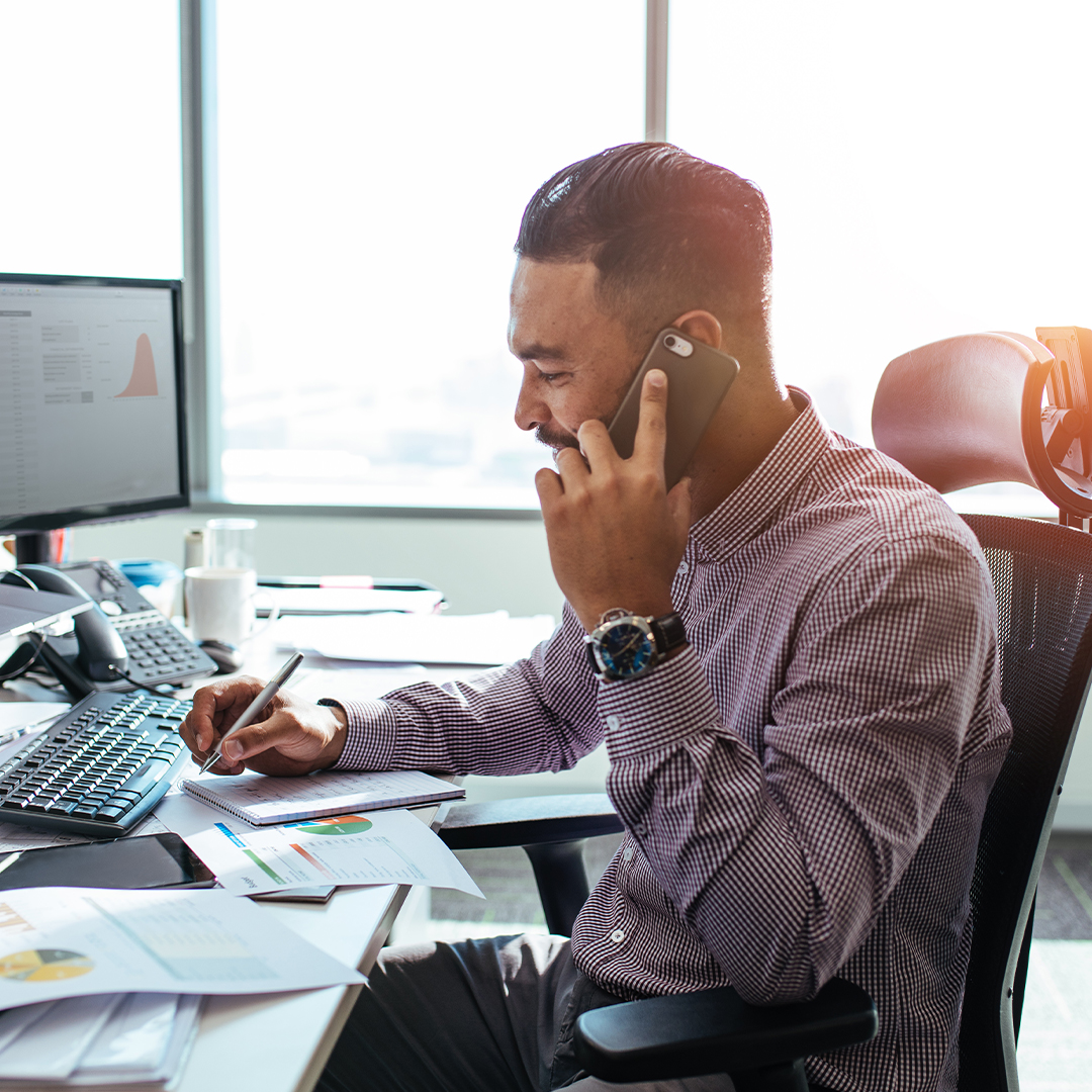 man on the phone at his desk